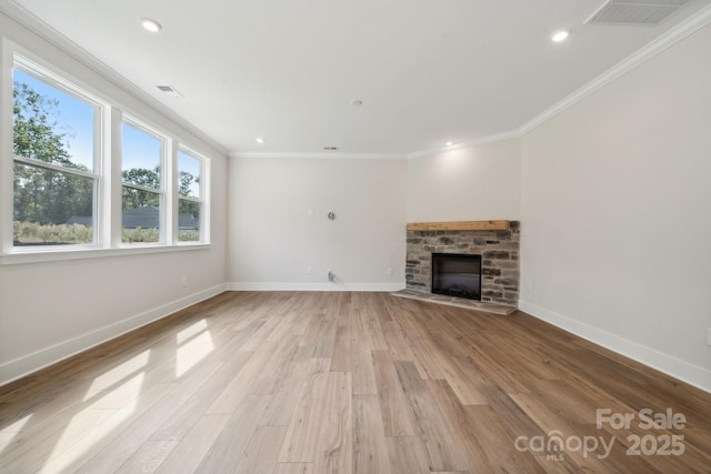 unfurnished living room featuring crown molding, light wood-type flooring, and a stone fireplace