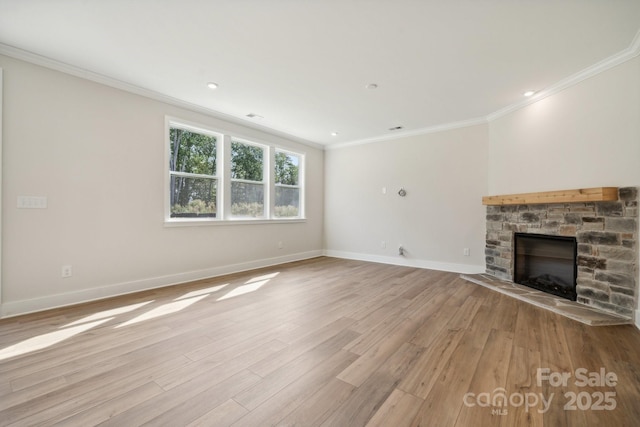 unfurnished living room featuring a stone fireplace, ornamental molding, and light hardwood / wood-style floors