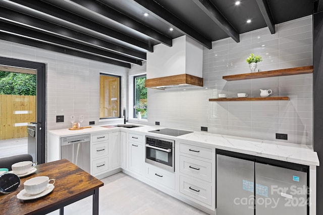 kitchen featuring appliances with stainless steel finishes, premium range hood, white cabinets, and beamed ceiling