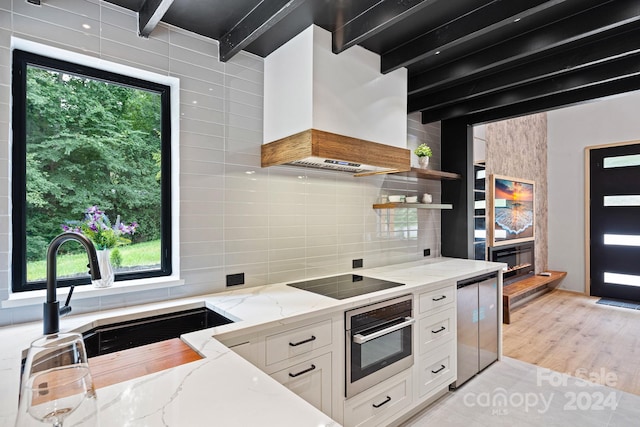 kitchen with beam ceiling, plenty of natural light, black electric cooktop, and oven