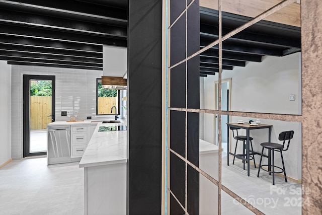 kitchen with white cabinets, sink, appliances with stainless steel finishes, and light tile patterned floors