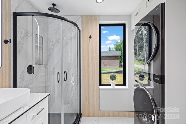 bathroom featuring plenty of natural light, vanity, tile patterned floors, and stacked washer / dryer