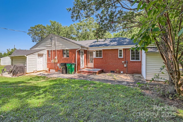 back of house with brick siding, a yard, a patio, a shingled roof, and crawl space