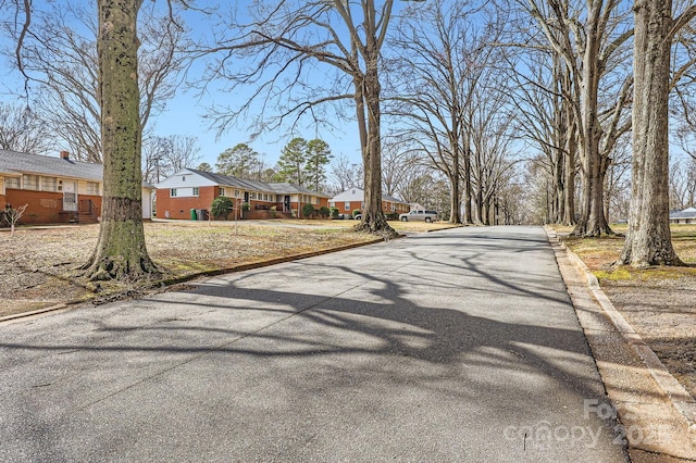 view of road featuring a residential view and curbs