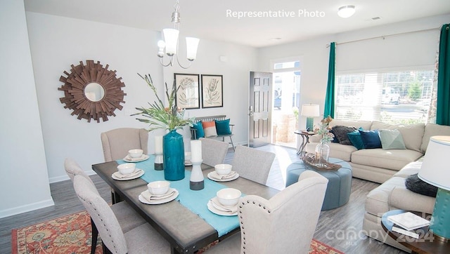 dining space with hardwood / wood-style flooring and an inviting chandelier