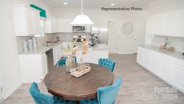 dining space with sink and light hardwood / wood-style floors