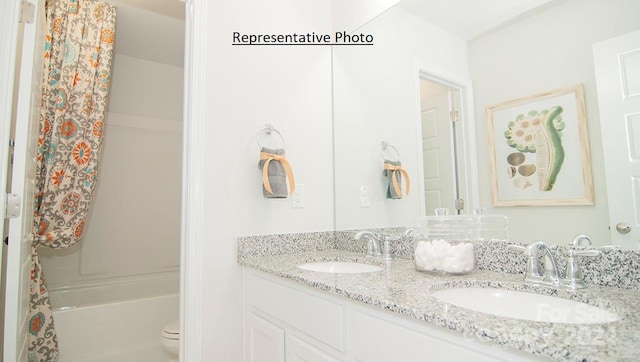 full bathroom with dual vanity, shower / bath combination with curtain, and toilet