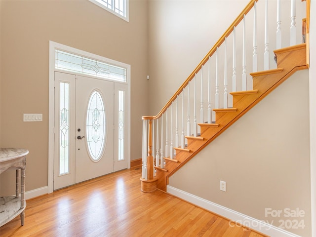 entryway with a high ceiling and light hardwood / wood-style floors