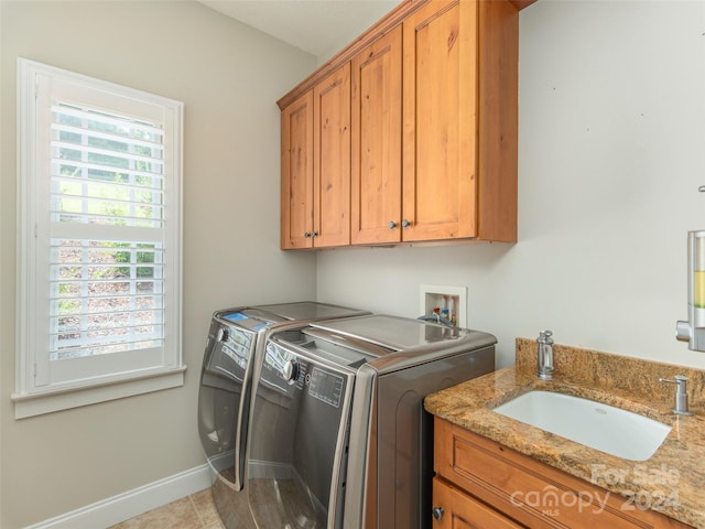 washroom featuring cabinets, light tile patterned floors, independent washer and dryer, and sink