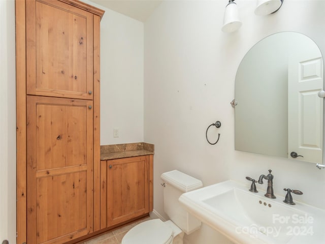 bathroom with tile patterned flooring, toilet, and sink