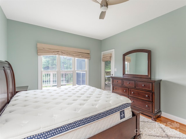 bedroom with light wood-type flooring, ceiling fan, and access to outside