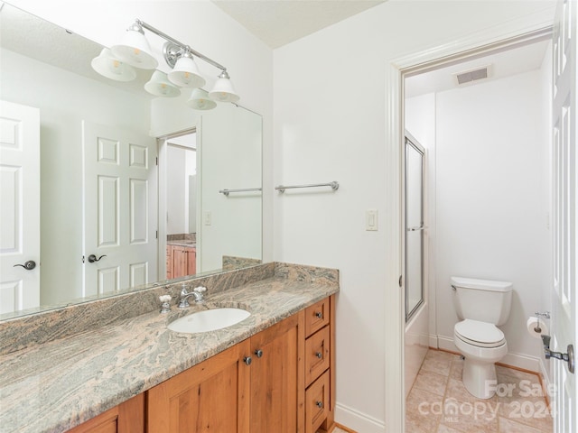 full bathroom featuring vanity, toilet, bath / shower combo with glass door, and tile patterned floors