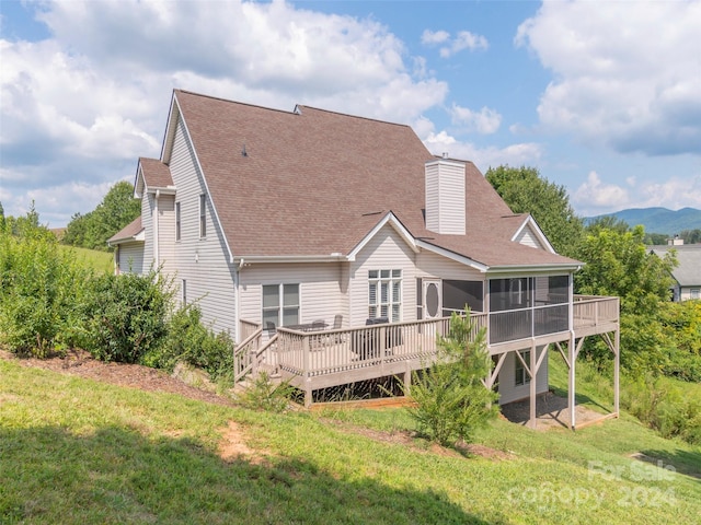 back of property with a yard, a sunroom, and a deck