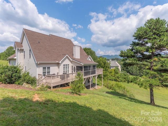 back of property with a yard and a deck