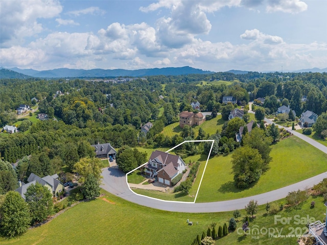 birds eye view of property featuring a forest view and a mountain view