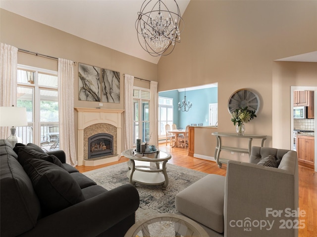 209 Velvet Ln, Weaverville, NC 28787 - living room with a chandelier, light wood finished floors, a tile fireplace, and high vaulted ceiling