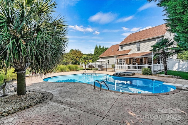 view of swimming pool featuring a fenced in pool, a patio, a hot tub, fence, and a diving board