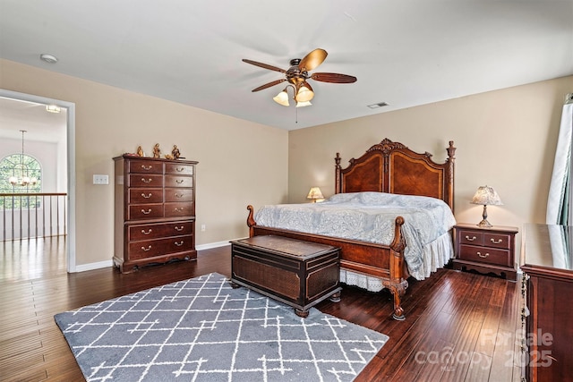 bedroom featuring visible vents, ceiling fan with notable chandelier, hardwood / wood-style flooring, and baseboards