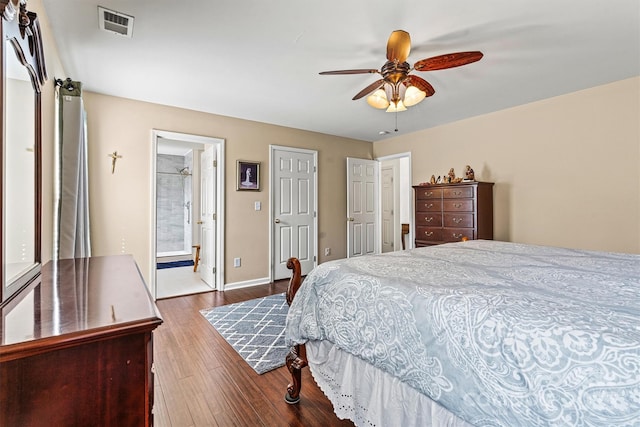 bedroom with ceiling fan, connected bathroom, wood finished floors, visible vents, and baseboards