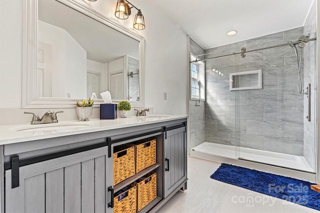 bathroom with a sink, double vanity, and a shower stall