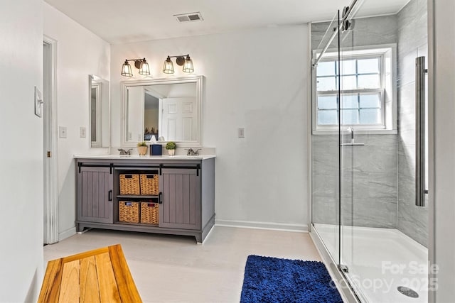 full bath featuring visible vents, a shower stall, baseboards, and double vanity