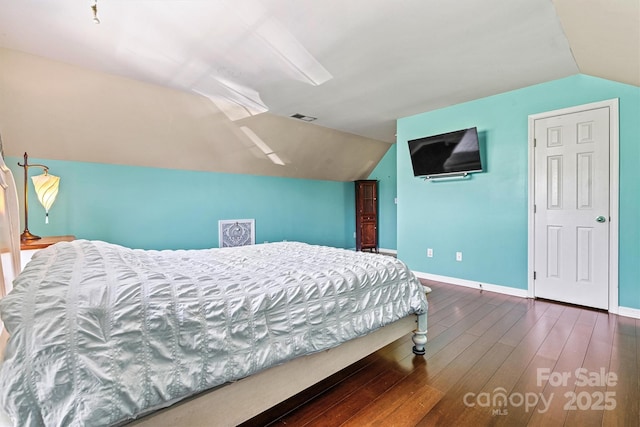 bedroom featuring visible vents, vaulted ceiling, baseboards, and wood finished floors