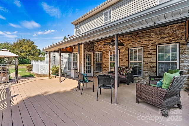 deck with ceiling fan, outdoor lounge area, and a gazebo