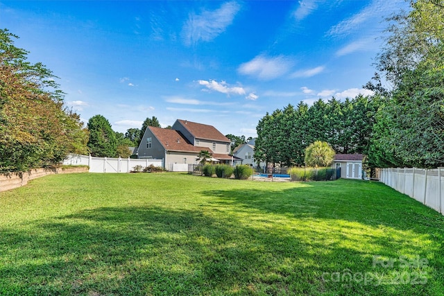 view of yard featuring a fenced backyard, a storage unit, and an outdoor structure