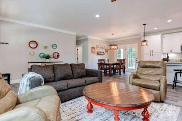 living room featuring light wood-type flooring and ornamental molding