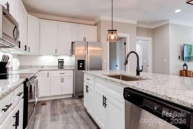 kitchen with sink, light hardwood / wood-style flooring, appliances with stainless steel finishes, and light stone counters