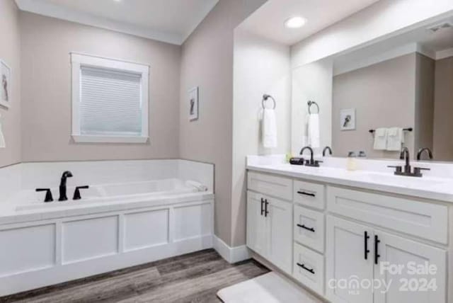 bathroom with a washtub, hardwood / wood-style floors, and vanity