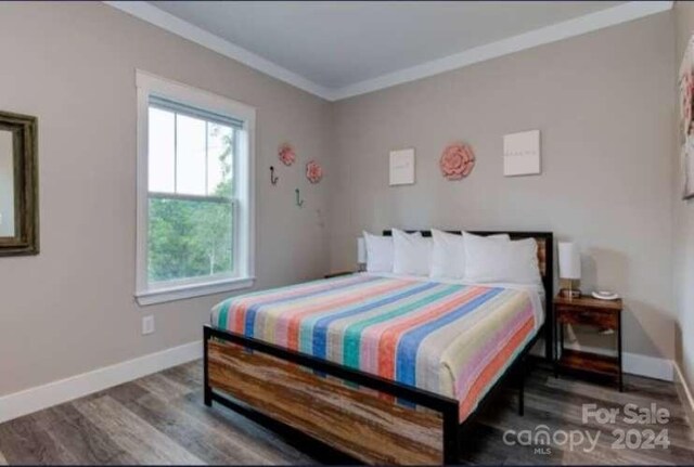 bedroom featuring ornamental molding and hardwood / wood-style flooring