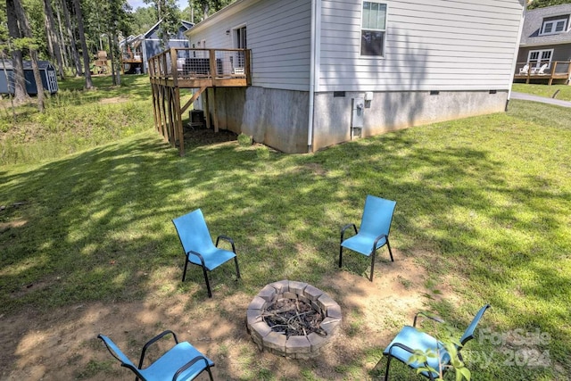 view of yard with a wooden deck and an outdoor fire pit