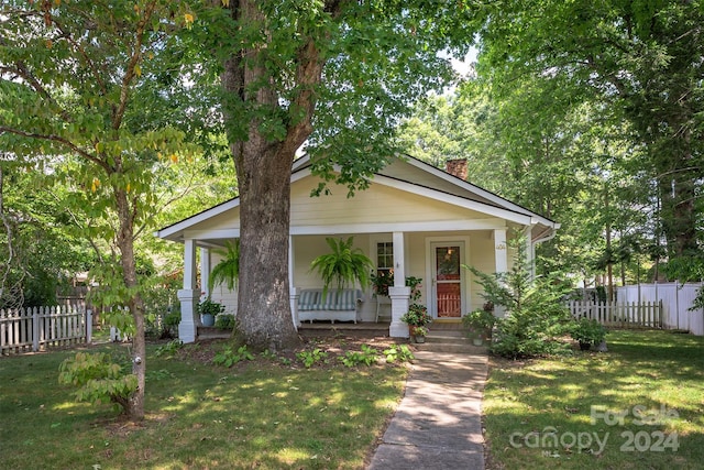 404 Montreat Rd, Black Mountain, NC 28711 - bungalow featuring a chimney, a front yard, a porch, and fence