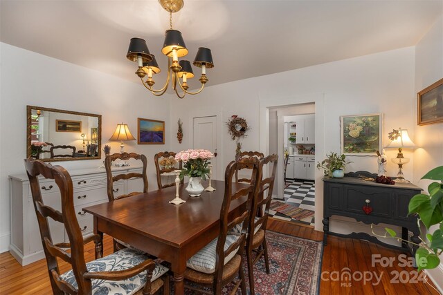 dining area with a chandelier and wood-type flooring