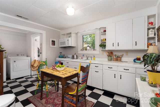 kitchen with white cabinetry, light tile patterned flooring, and white appliances