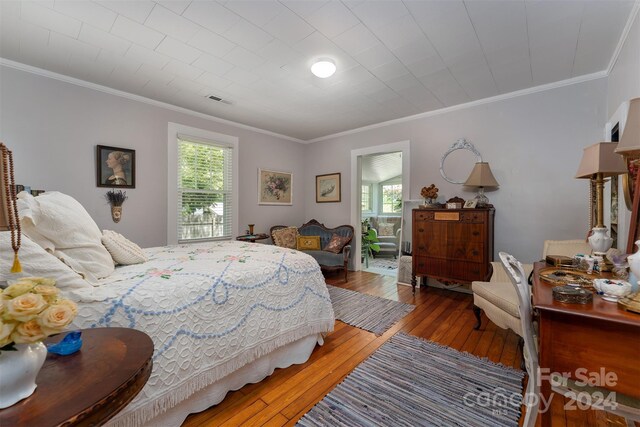 bedroom with crown molding and hardwood / wood-style flooring