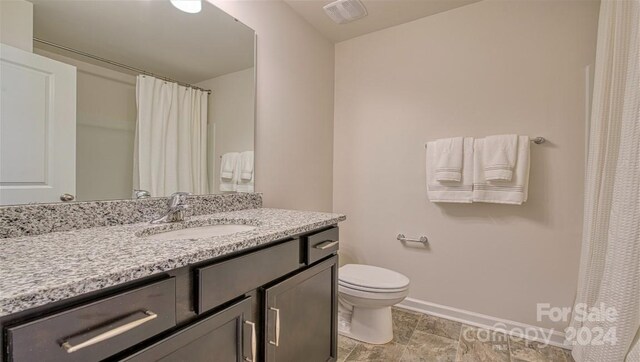 bathroom featuring tile patterned floors, vanity, and toilet