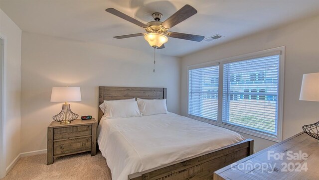 bedroom with ceiling fan and light colored carpet