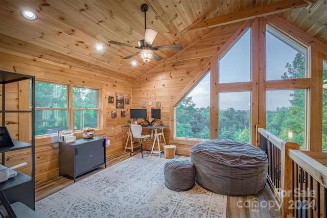 office space featuring wood-type flooring, wood ceiling, ceiling fan, wooden walls, and vaulted ceiling with beams