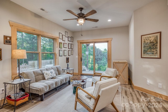 living room with light wood-type flooring and ceiling fan