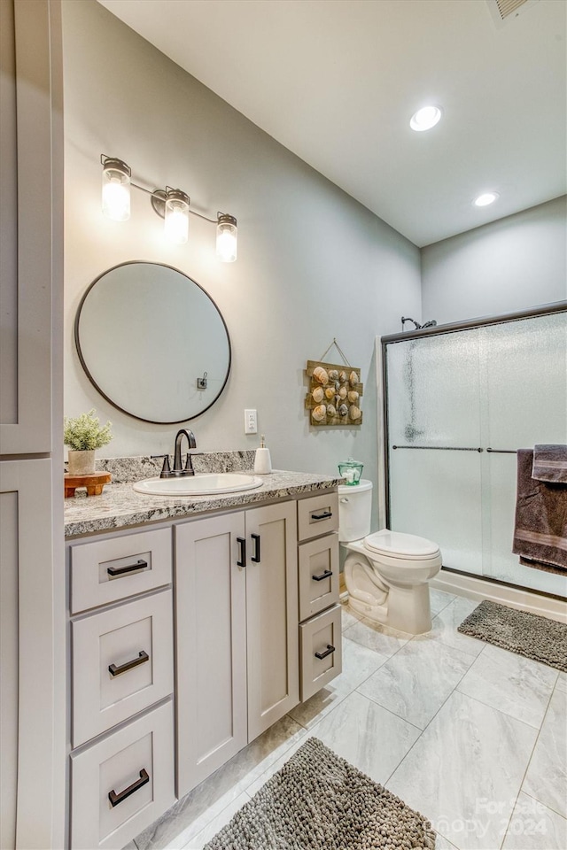 bathroom featuring vanity, toilet, and walk in shower