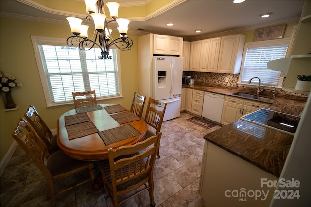 kitchen with white appliances, decorative light fixtures, ornamental molding, and sink