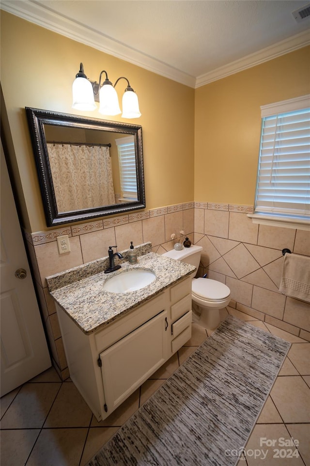 bathroom with ornamental molding, vanity, tile walls, tile patterned flooring, and toilet