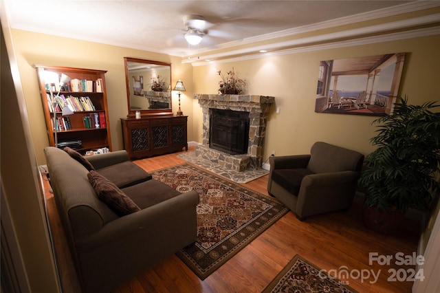 living room with a fireplace, hardwood / wood-style floors, ceiling fan, and ornamental molding