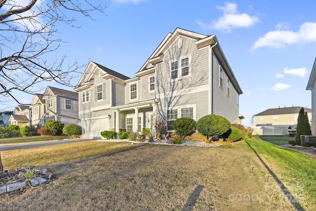 view of front of house featuring a front yard, a garage, and central AC unit