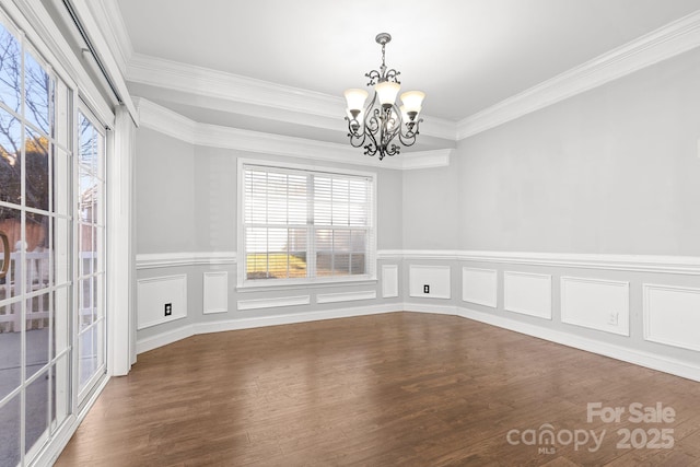 unfurnished room featuring wood-type flooring, crown molding, and a chandelier