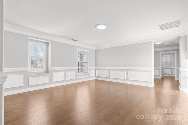 spare room with wood-type flooring and crown molding