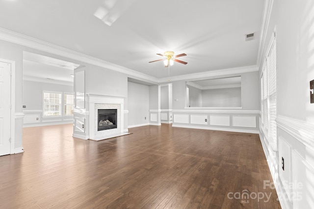 unfurnished living room featuring ceiling fan, wood-type flooring, a premium fireplace, and crown molding