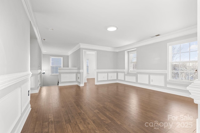 interior space featuring a healthy amount of sunlight, dark wood-type flooring, and ornamental molding